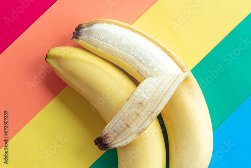 LGBT love concept, two bananas lie on the rainbow flag, a symbol of male love, close-up