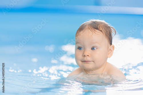 Portrait happy baby girl in swimming pool, teaching small swimmer. Concept healthcare sport for infant