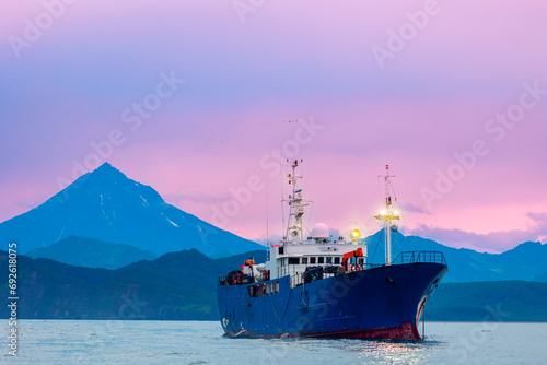 Landscape ship for fishing industry on background Vilyuchinsky Volcano, Kamchatka Peninsula Russia.