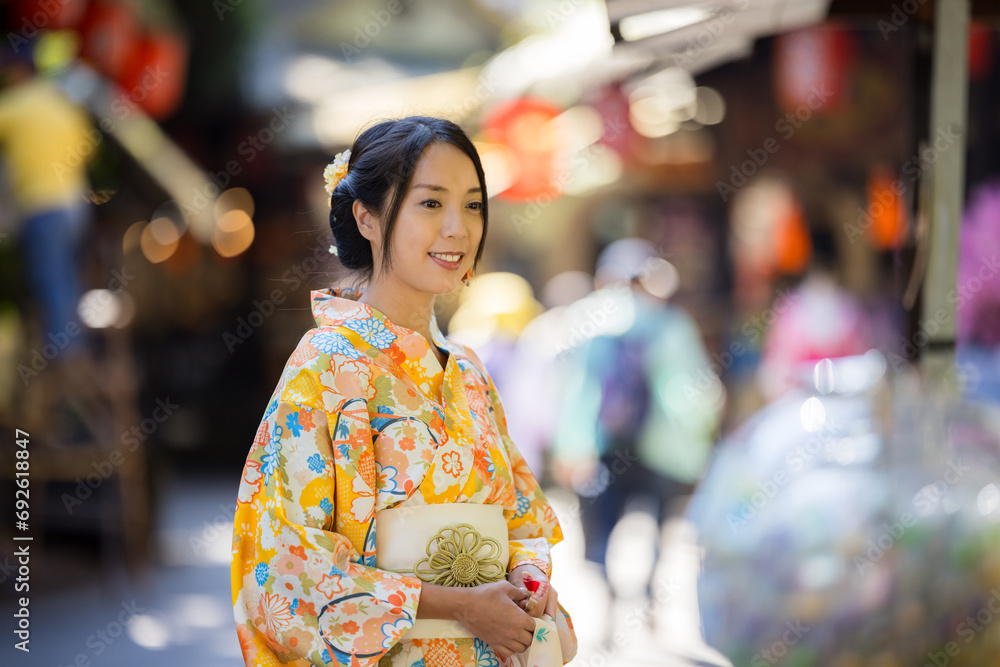 Asian woman try to wear Japanese kimono with the traditional Japanese village background