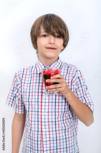 Teenage boy holding watermelon smoothie in his hand