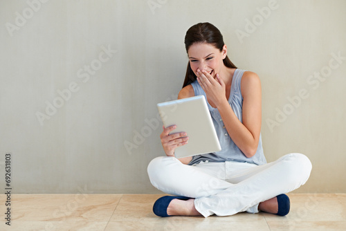 Happy woman, tablet and laughing for funny joke, social media or meme sitting on floor at home. Female person, brunette or freelancer smile and giggling with technology for humor or comedy on mockup