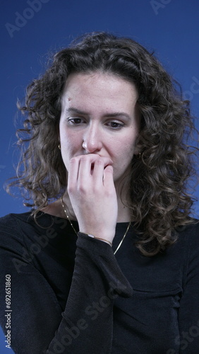 Anxious woman biting nails feeling apprehensive about future, struggles with obsessive compulsion in vertical video