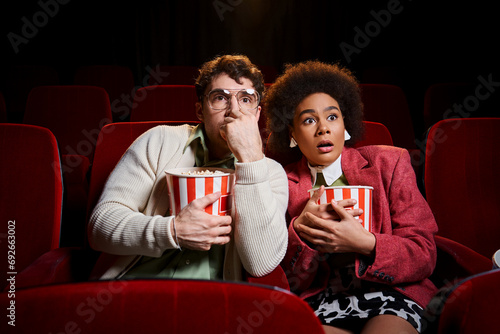 astonished shocked diverse couple in retro stylish attires watching movie at cinema, Valentines day