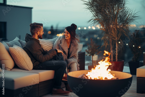 Happy couple having a romantic date on outdoor terrace with fire pit in winter photo