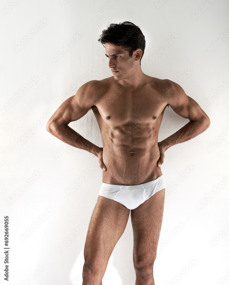 Man, underwear and wall background with body, healthy and thinking with vision, fitness and health. Guy, person and briefs with ideas, memory or choice with strong muscle, abdomen and wellness