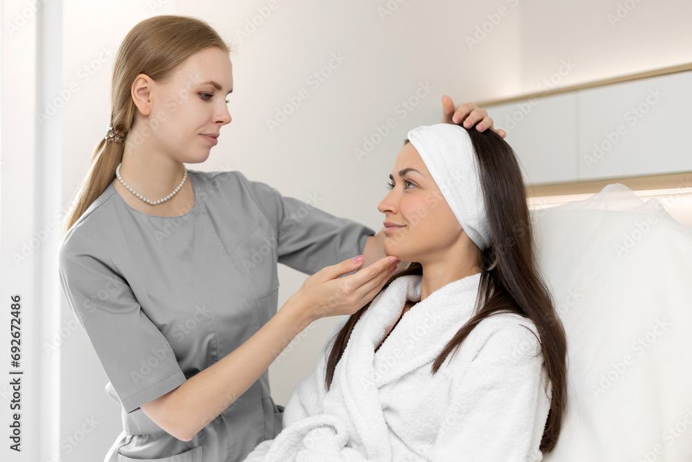 A beautician advises a woman on facial skin care in a beauty salon A beautician advises a woman on facial skin care in a beauty salon
