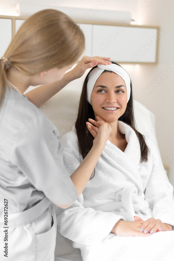 Fototapeta premium Cosmetologist analyses the woman's skin face in beauty salon