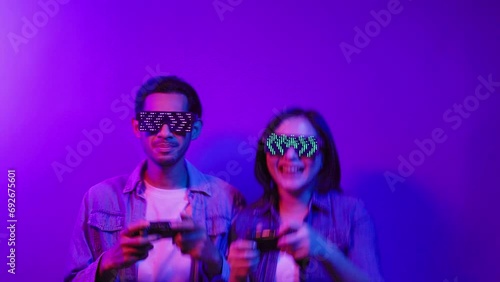 Mobile gaming. Neon light people. Esport tournament Cyber sport.   blue color excited Asian people enjoying playing online on smartphone isolated on violet background.