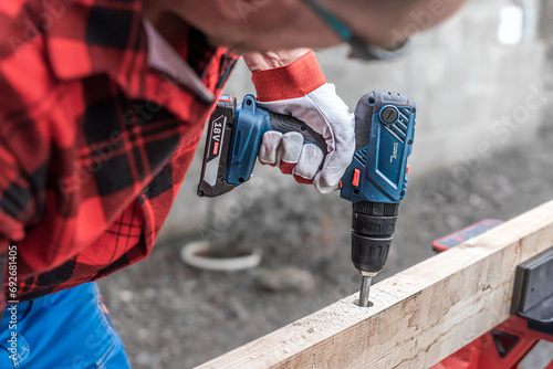The cordless drill in worker hand during work. 