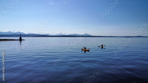 Young people kayaking in the ocean. Endless view of the Vancouver Islands. Beautiful colors