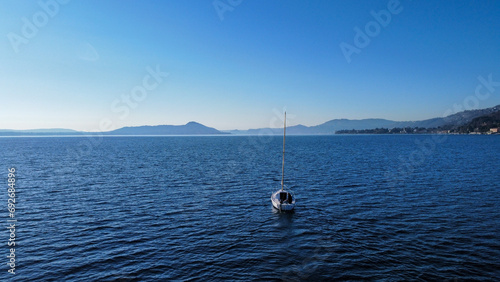 Sailing boat in Italy, Lombardia, Angera on the Lago Maggiore; In the background the mountains