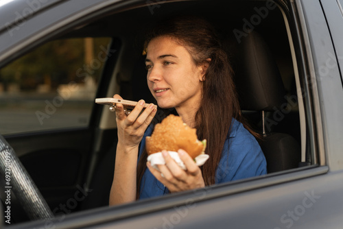 Foto Focused woman sitting in car when recording voice message on smartphone