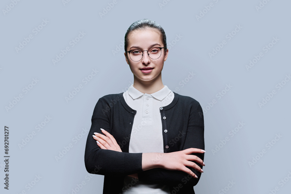 Portrait of confident smiling teenager girl on grey background Portrait of confident smiling teenager girl on grey background