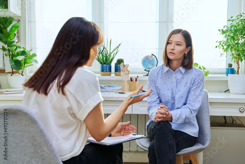 Young woman at mental therapy, talking to female psychologist