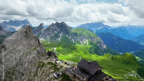 Aerial view of Rifugio Nuvolau, the oldest mountain hut refuge in the Dolomites, Italy. Clouds covering the mountains in the background. Beautiful destinations for hikers and alpinists. Cinematic shot photo