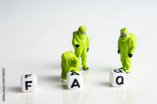 faq word or concept made by white letter cubes on white and gray background, frequently asked questions abbreviation with miniature hazmat firemen figurines having a gathering photo