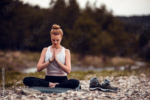 Young redhead woman meditating in nature photo