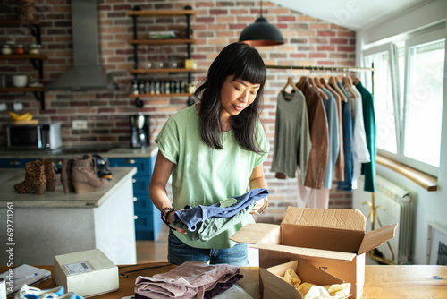Young woman working in online store office packing shipment photo