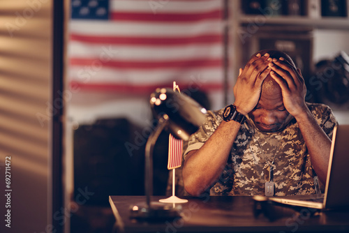 American soldier being tired and missing home while being deployed in an army base photo