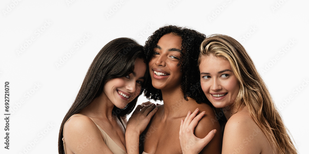 Three confident and happy women smiling cheerfully. Women standing together against a studio background. Three confident and happy women smiling cheerfully. Women standing together against a studio background.