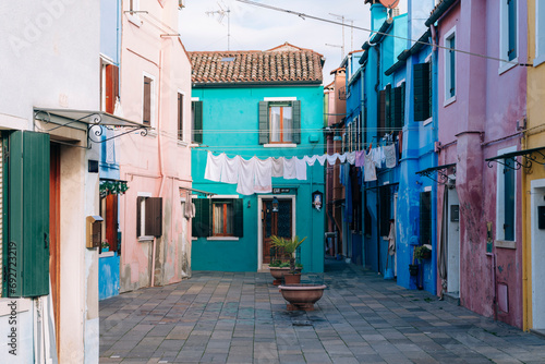 The daily life of Burano, Venice is captured with lines of laundry stretched between the colorful houses of the island photo