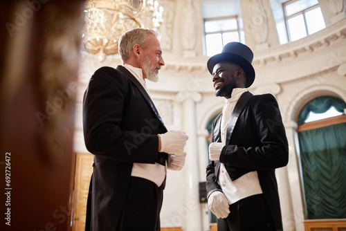 Photography Low angle view at two gentlemen wearing classic tailcoats enjoying conversation