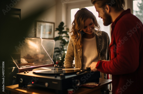 Couple listening to a vinyl records and enjoying at home. Romantic scene.