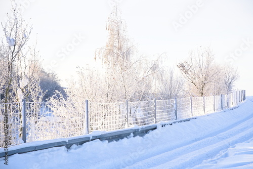 sonnige Winterlandschaft und verschneiter Zaun © alho007