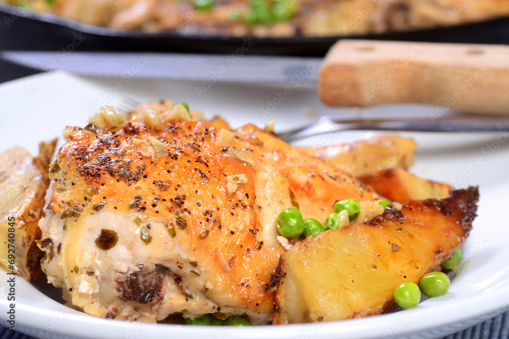 Chicken Vesuvio on a plate served with potatoes and peas