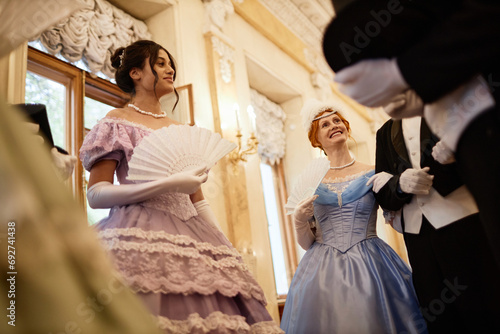 Obraz na plátně Low angle view at group of ladies and gentlemen chatting in ballroom