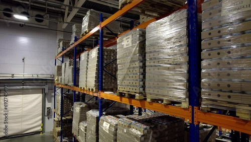Packaged labelled goods on tiered shelves in warehouse. Goods ready for transportation kept on shelves in storage facility waiting for trucks