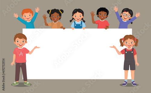 Group of kids students boys and girls standing behind empty banner or poster templates for text banner and ads