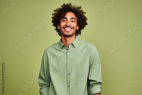 Portrait of a happy young african american man with curly hair on green background