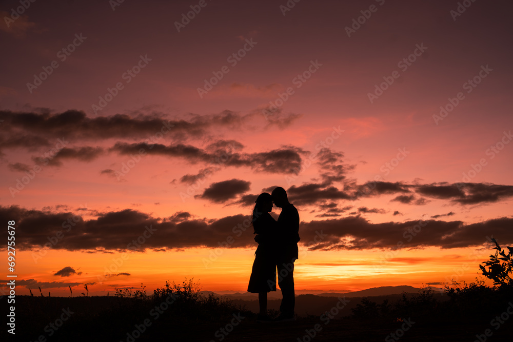 silhouette of a couple on the hill at sunset