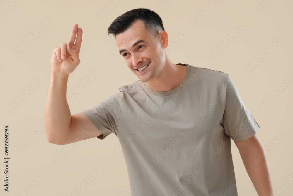 Young man saluting on beige background Young man saluting on beige background