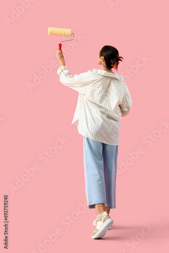Young woman with paint roll...