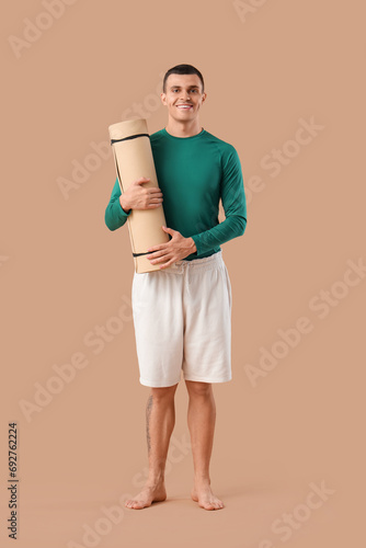 Young man with yoga mat on ...