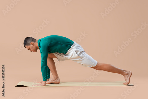 Young man doing yoga on mat...