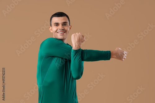 Young man doing yoga on bro...