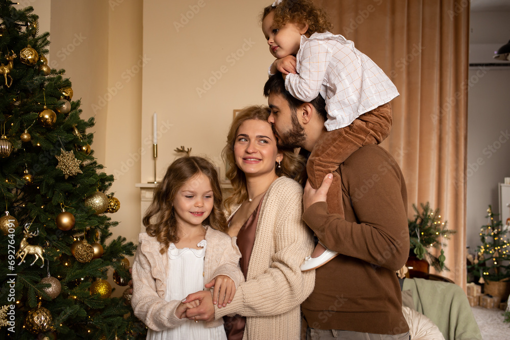 parents and two sisters children near Christmas tree
