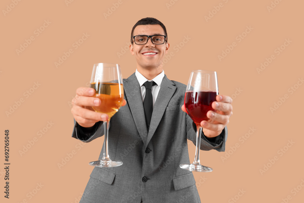 Young sommelier with glasses of wine on beige background Young sommelier with glasses of wine on beige background