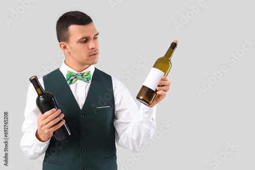 Young barman with bottles o...