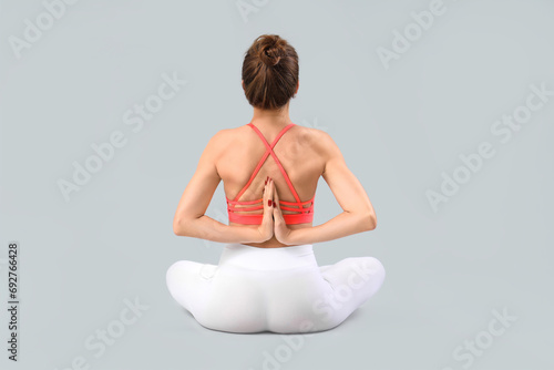 Young woman doing yoga on g...
