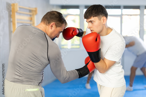 Portrait of defferent ages serious active sportsmen competing in boxing gloves photo