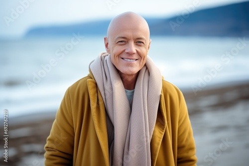 A middle age man with cancer without hair peacefully meditating on a serene beach near sea