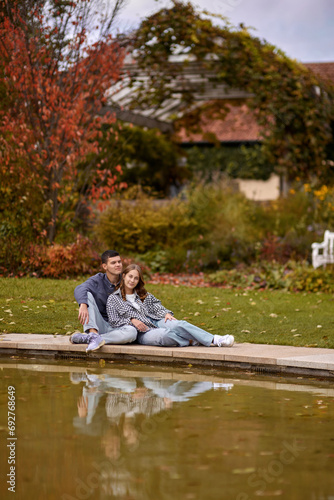 Young couple kissing and rejoices at the lake. lovely young couple kissing outdoors in autumn. Loving couple walking in nature. Autumn mood. Happy man and woman hugging and kissing in autumn. Love
