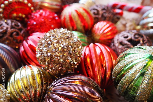 New Year's Christmas balls and decorations close up. A lot of decor of gold, red, yellow, brown, green, silver. Striped Christmas balls lie in a bunch. Festive beautiful colorful background. Design