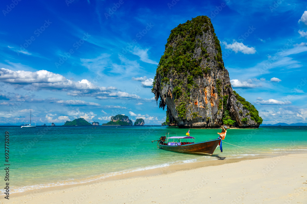 Obraz premium Long tail boat on tropical beach with limestone rock, Krabi, Thailand
