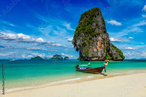 Long tail boat on tropical beach with limestone rock, Krabi, Thailand photo